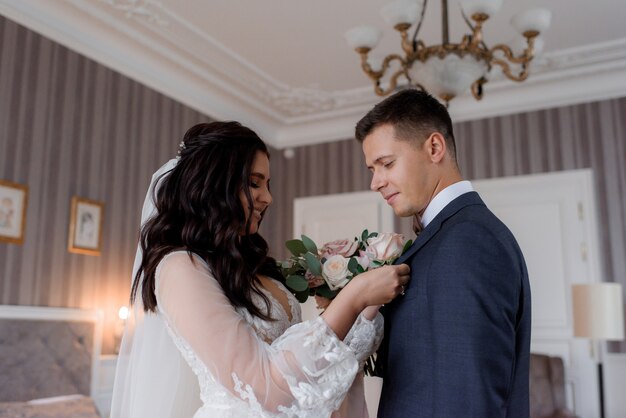 Wedding couple are preparing together for the wedding ceremony with dressing on boutonniere