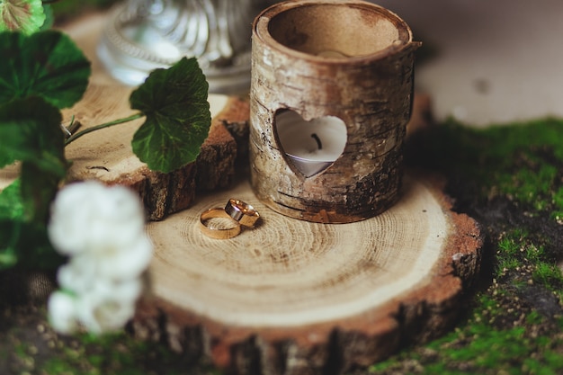 Free photo wedding golden rings on the stump in a green grass