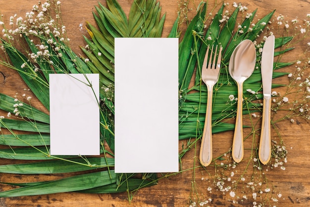 Free photo wedding menu concept with leaves and cutlery