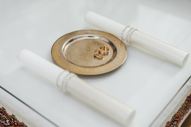 Free Photo wedding rings on the golden tray on the white table