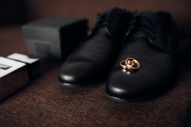 Free photo wedding rings lie on the man's shoes