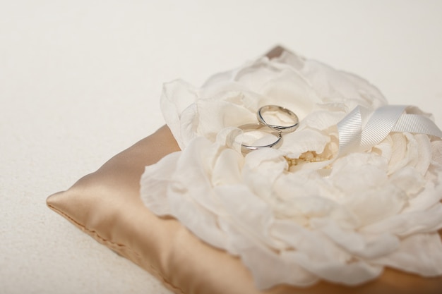 Free photo wedding rings made of white gold lie on the cloth flower