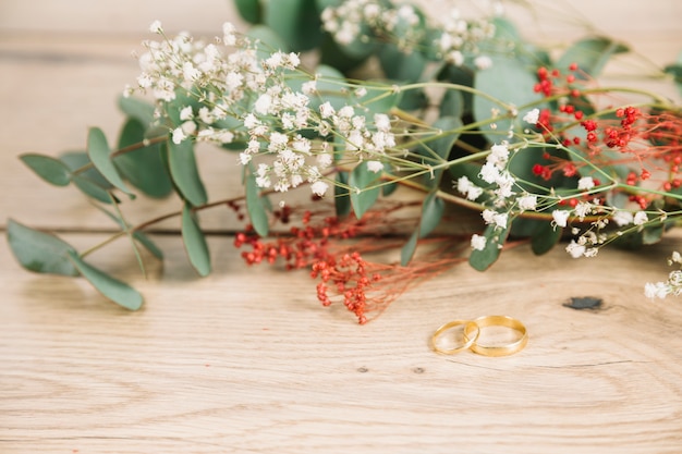 Free photo wedding rings with bouquet of flowers