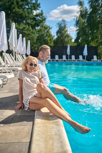 Weekend. Mature couple enjoying good weather near the swimming pool