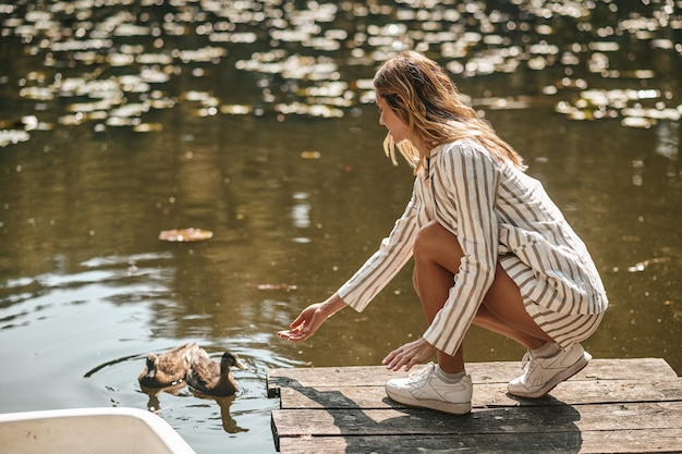 Free photo weekend. young woman spending a day in the park near the water