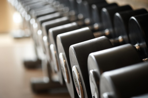 Free photo weight training equipment in a modern gym indoors. close-up image of dumbells on a stand. gym equipment.