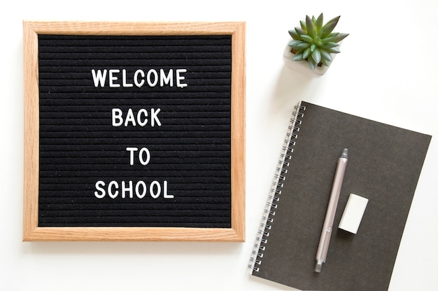 Free photo welcome back to school text on slate near stationeries over white background