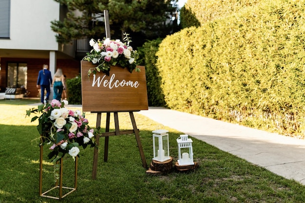 Free photo welcome board at wedding reception in a garden.