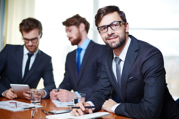 Free photo well-dressed executive with co-workers background