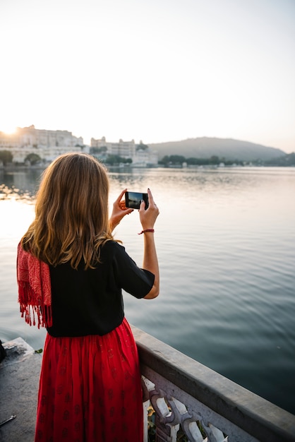 Free Photo western woman capturing the view of udaipur city, india