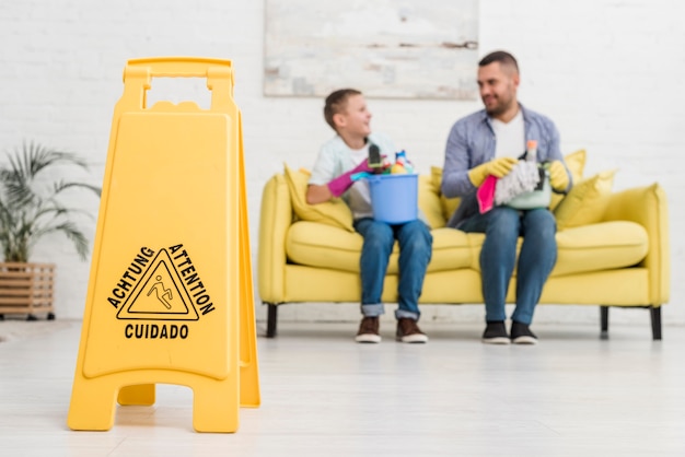 Wet floor sign with defocused father and son