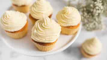 Free photo whipped cream on muffins over cake stand