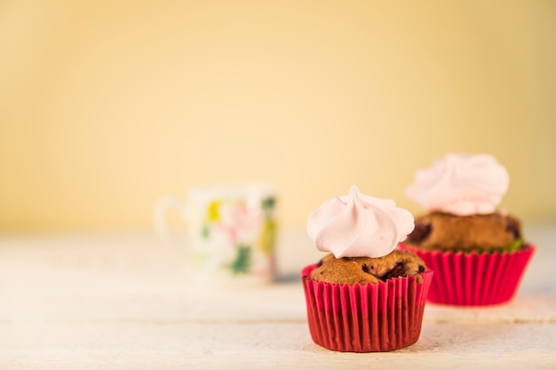 Free photo whipped cream on muffins in the red paper holder