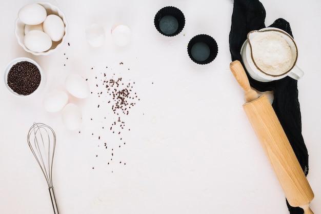 Free photo whisk and rolling pin near pastry ingredients