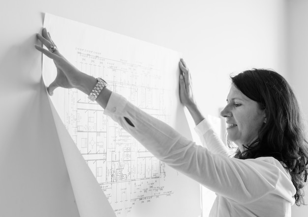 Free Photo white architect showing building plan on white wall