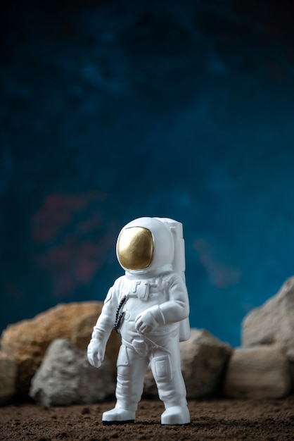 Free photo white astronaut around rocks on a moon blue  fantasy cosmic sci fi