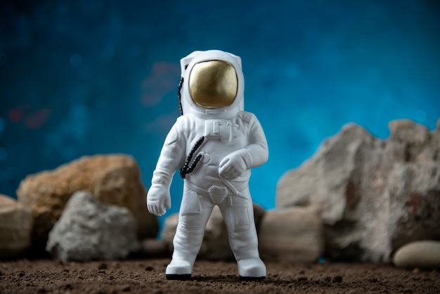 Free photo white astronaut with rocks on a moon blue  fantasy cosmic sci fi