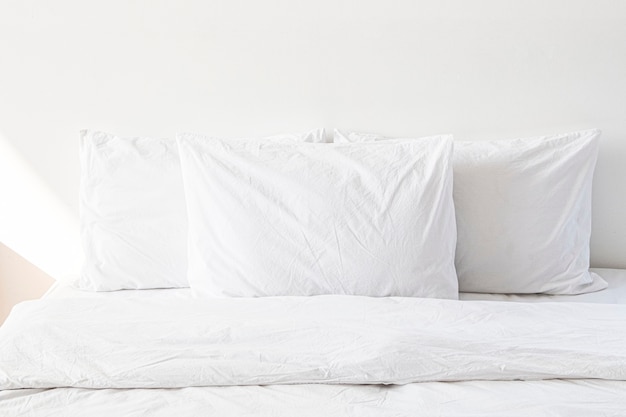 White bed linen on a bed in a white bedroom