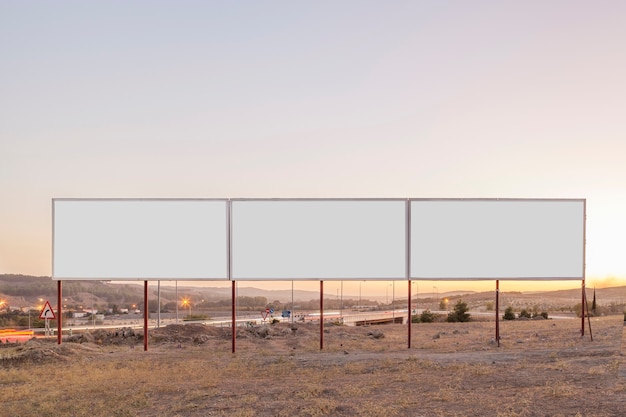 Free photo white billboards for advertisement near the highway during sunset