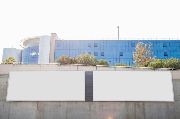 White blank billboards on concrete wall in front of corporate building