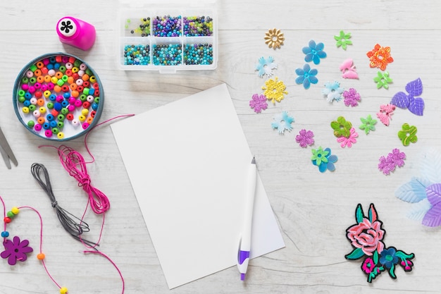 Free Photo white blank paper with pen and colorful decorative elements on white textured background