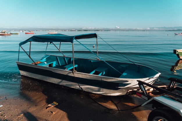 White and blue boat on the shore in Rio