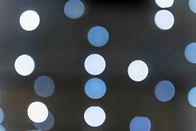 White and blue glowing bokeh on dark backdrop