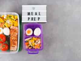 Free photo white board with meal prep inscription near food in containers