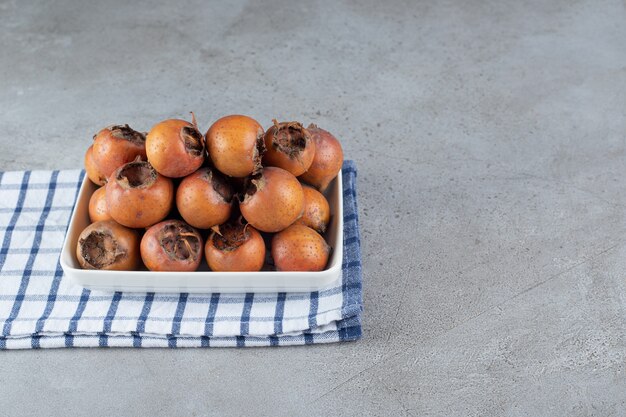 A white board with ripe persimmons on a tablecloth. High quality photo