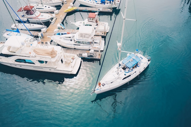 White boat leaving the marina docks sailing on the water