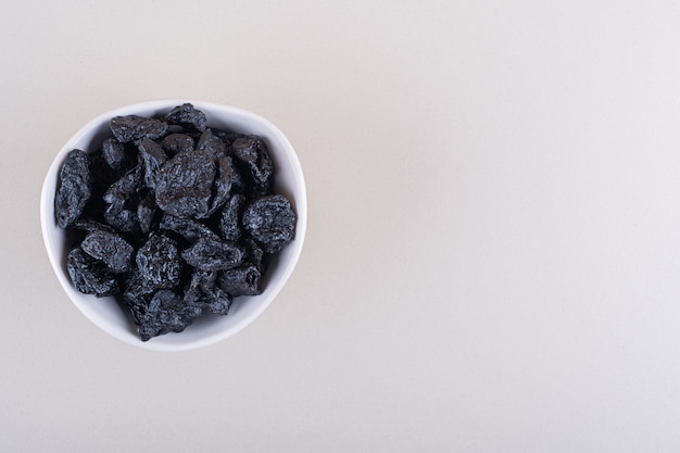 Free Photo white bowl of dried plum fruits placed on white background. high quality photo