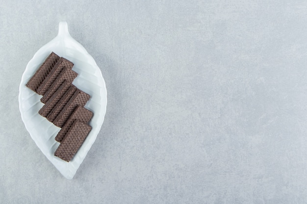 A white bowl full of chocolate waffles . 