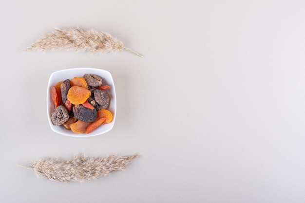 White bowl full of dried fruits