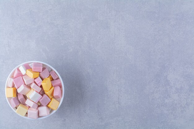 A white bowl with pink and yellow sweet confectionery Pastila . High quality photo