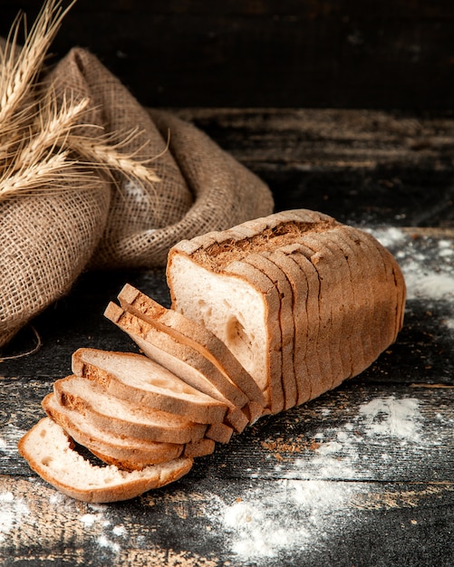 white bread sliced white bread with fllour and wheat on table