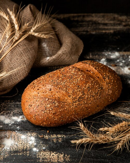 white bread with sesame seeds flour and wheat on table