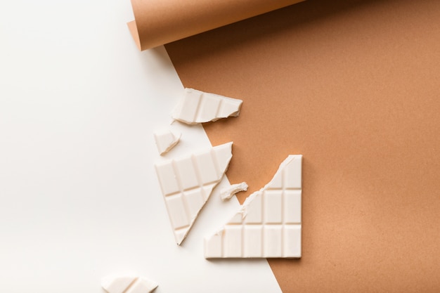 Free photo white broken chocolate bar on dual background