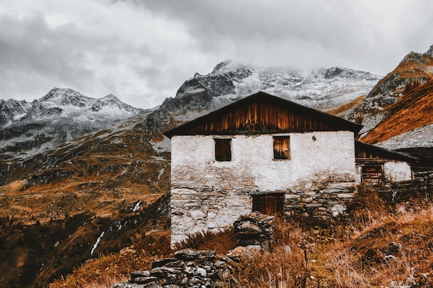 Free Photo white and brown house near snow capped mountains