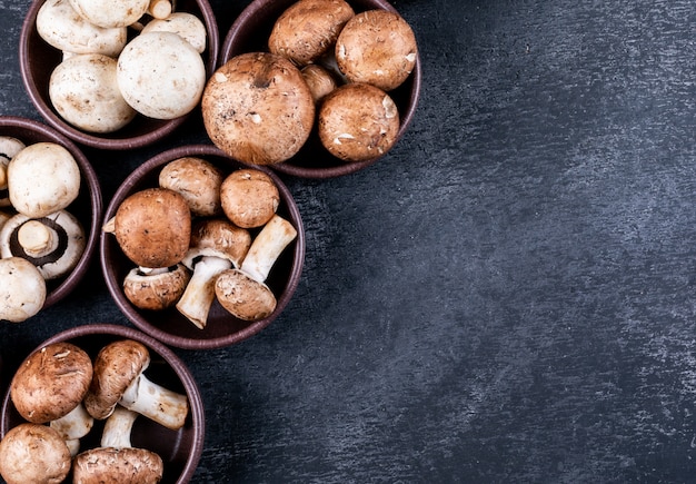 White and brown mushrooms in a lot of bowls