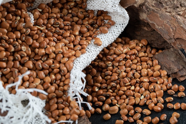 A white burlap with unprepared brown kidney beans 