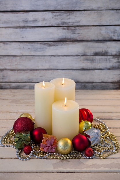 Free photo white candles lit with christmas decoration