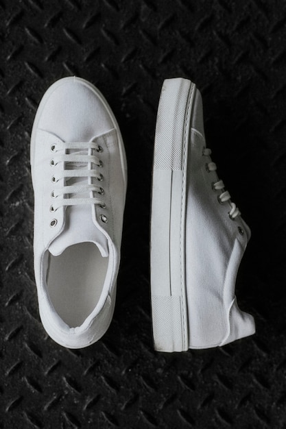 Free photo white canvas sneakers on metal floor