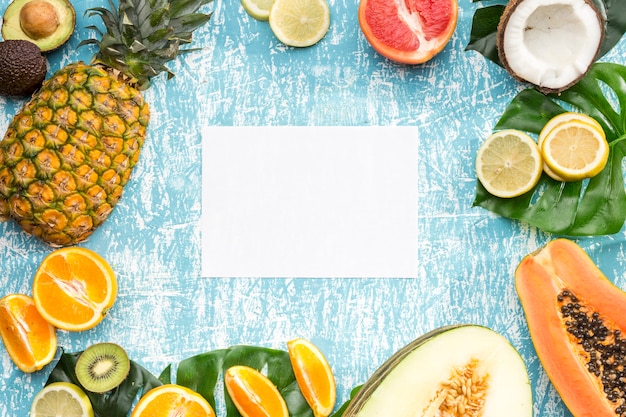 Free photo white card surrounded by exotic fruits