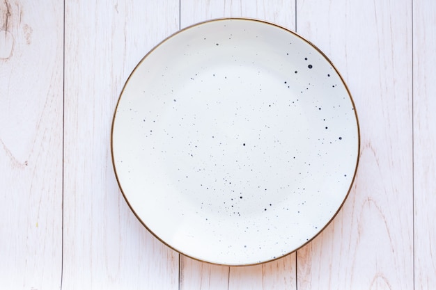 White ceramic plate on wood surface, top view