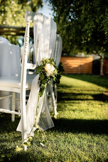 White chair with rose bouquet at outdoor wedding venue.