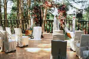 Free photo white chairs stand before wedding altar on the porch