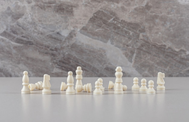 Free Photo white chess pieces displayed on marble 