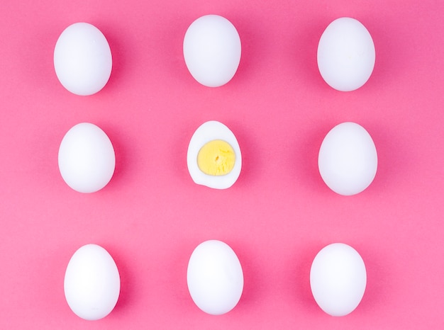 White chicken eggs with boiled egg on table