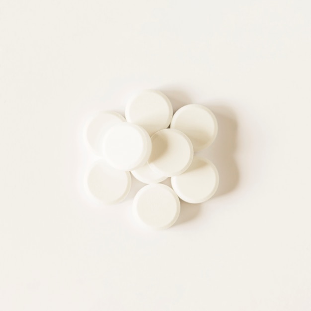 White circular pills over white background