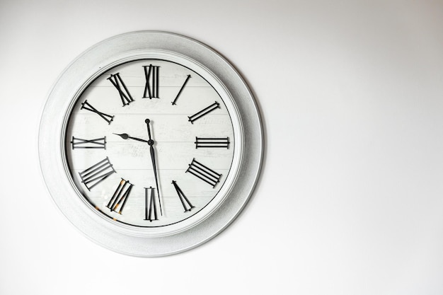 Free Photo white clock on a white wall in the interior